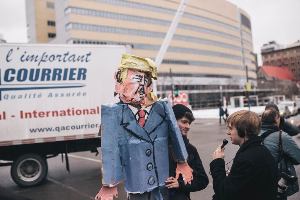 Journalist Ian Down interviewing protester Jonathan Ouzariman, who made paper-mâché effigy of President Trump. Photo by Kirubel Mehari.